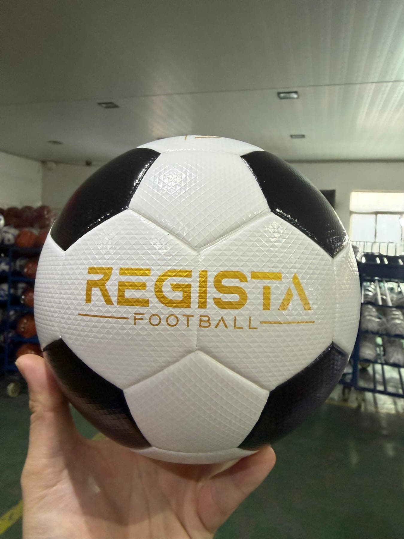The Size 3 Ball, black and white panels with a gold Regista Football wordmark across the front.